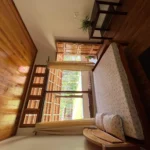 Relaxing room with scenic window view of Coorg's nature at Rosewood Stay